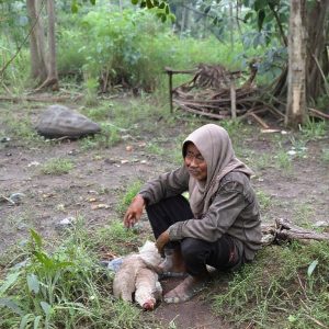 Seorang agen Himbara sedang melayani nasabah di sebuah warung kecil di pedesaan.